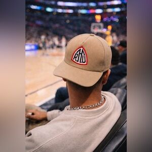 Rhude Beige Hat with Red and Black Emblem